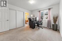 Carpeted room featuring a double-door closet, a white panel door, and a window with a curtain rod - 