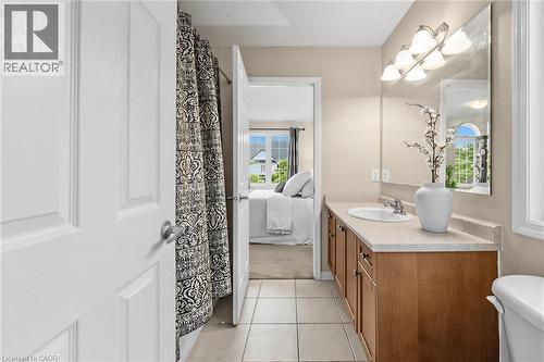 Bathroom featuring a single vanity with wood-finish cabinetry, a light-toned countertop, and an integrated sink - 729 Boughton Crescent, Milton, ON 