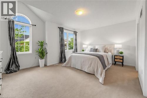 Carpeted room featuring multiple windows, including a large arched window - 729 Boughton Crescent, Milton, ON 