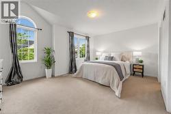 Carpeted room featuring multiple windows, including a large arched window - 