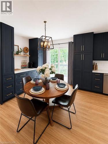 Kitchen featuring full-height navy cabinetry with brass hardware, white countertops, and wood-finish flooring - 355 East 36Th Street, Hamilton, ON 