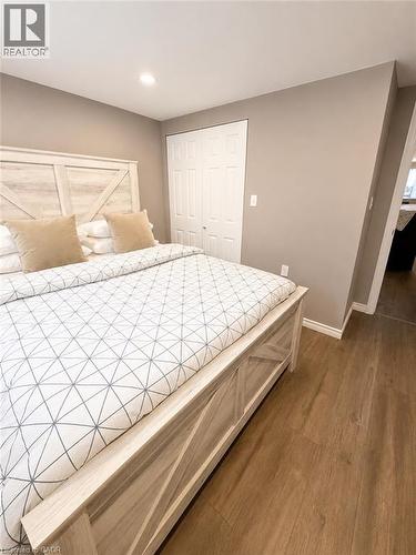 Spacious bedroom featuring wood-finish flooring, neutral-toned walls, recessed lighting, and a bi-fold closet - 355 East 36Th Street, Hamilton, ON 