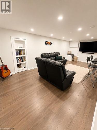 Spacious room featuring wood-finish flooring, recessed lighting, and a built-in bookshelf - 355 East 36Th Street, Hamilton, ON 