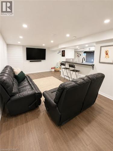 Finished lower level featuring recessed lighting, wood-finish flooring, and a contemporary wet bar - 355 East 36Th Street, Hamilton, ON 