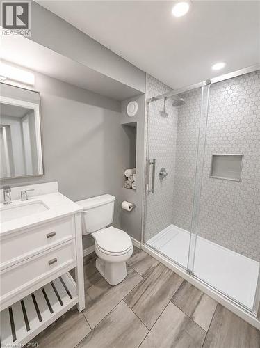Bathroom featuring a glass-enclosed shower with honeycomb tile, a built-in shower niche, and a rain shower head - 355 East 36Th Street, Hamilton, ON 