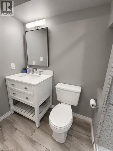 Contemporary bathroom featuring a white vanity with integrated sink, chrome faucet, and storage drawers - 355 East 36Th Street, Hamilton, ON 