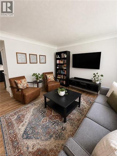 Living area featuring wood-finish flooring, light-colored walls, and crown molding - 355 East 36Th Street, Hamilton, ON 