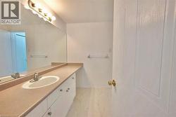Spacious vanity with an integrated sink and ample counter space, complemented by an elongated mirror - 