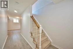 Carpeted staircase with a light wood handrail and white balusters - 