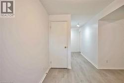 Bright interior hallway featuring light wood-finish flooring and track lighting - 
