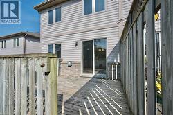 Wood deck with a wooden privacy fence, featuring a sliding glass door entry to the building, a brick foundation, and horizontal siding - 