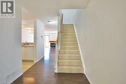 Carpeted staircase with a wood handrail - 