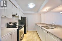 Kitchen featuring white cabinetry, light countertops, and tile flooring - 