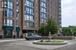 Multi-story building featuring a prominent entrance with green awnings and oversized windows - 