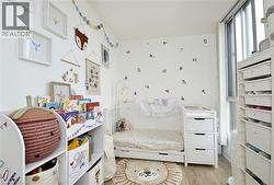 Light-filled room featuring hardwood-finish flooring, white walls, and a large window - 