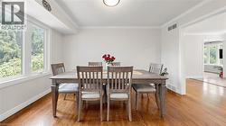 Formal dining area featuring hardwood flooring, multiple windows, and crown molding - 