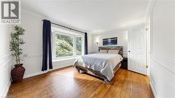 Hardwood flooring throughout featuring white wainscoting and crown molding - 