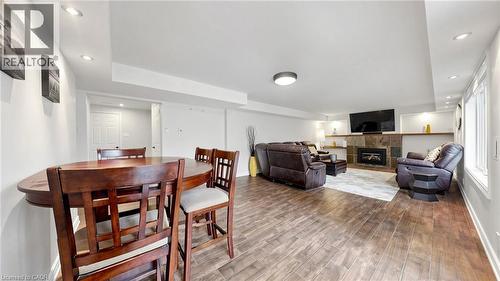 Finished lower level featuring wood-finish flooring, recessed lighting, and a stone-surround fireplace with a wood mantle - 438 Lexington Road, Waterloo, ON 