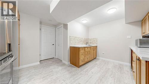 Kitchenette featuring light wood cabinetry, a stainless steel refrigerator, white countertops, and a subway tile backsplash - 438 Lexington Road, Waterloo, ON 