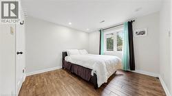 Room featuring wood-finish flooring, white baseboards, and neutral wall paint - 