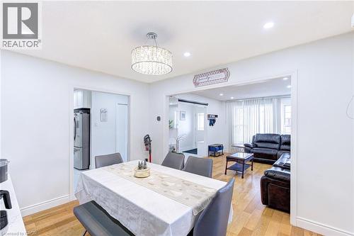 Dining area featuring wood-finish flooring, recessed lighting, and a decorative drum chandelier - 214 Merrilee Crescent, Hamilton, ON 