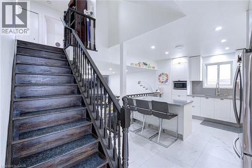 Dark wood staircase with carpeted treads and classic balusters - 214 Merrilee Crescent, Hamilton, ON 