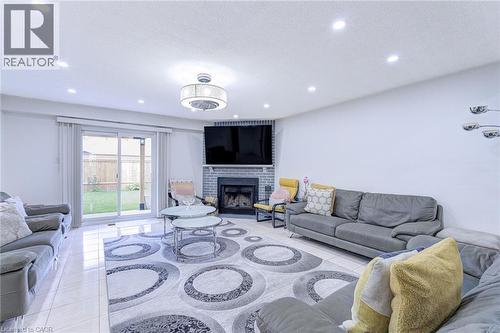 Spacious living area featuring polished tile flooring and recessed lighting - 214 Merrilee Crescent, Hamilton, ON 