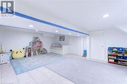 Spacious recreational room featuring recessed lighting, white walls, and a tiled floor - 