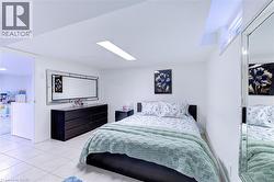 Bedroom featuring neutral wall paint, tile flooring, and a recessed window - 