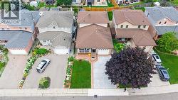 Multi-story property with a brown shingle roof, beige siding, and a covered porch - 
