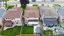 Aerial perspective of a detached residential property featuring a fenced backyard with a green lawn - 