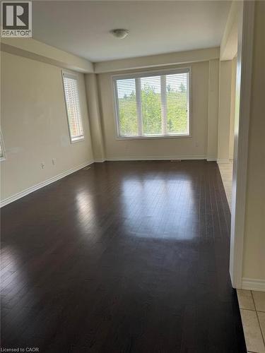Expansive room featuring dark wood-finish flooring, multiple windows with blinds, and light neutral wall tones - 63 Ridge Road Unit# Upper, Cambridge, ON 