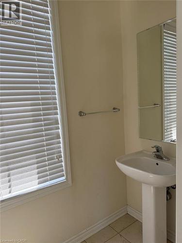 Pedestal sink with chrome faucet, complemented by a wall-mounted mirror - 63 Ridge Road Unit# Upper, Cambridge, ON 