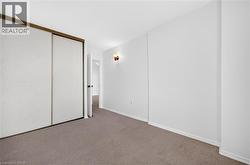 Interior room featuring neutral carpeting and white painted walls, providing a blank canvas for personalization - 