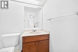 Bathroom featuring a wooden vanity with a built-in sink, stone-finish countertop, and a wall-mounted mirror - 