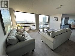High-rise living room with large windows, recessed lighting, and neutral carpet flooring - 