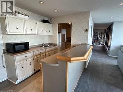 Entertainment area featuring a wet bar with a double sink, light-toned cabinetry, and recessed lighting - 