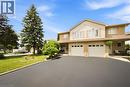 Two-story residence featuring a brick and siding facade, arched window above the entry, double garage, and a paved driveway - 16 Scottacres Boulevard, Caledonia, ON  - Outdoor With Facade 