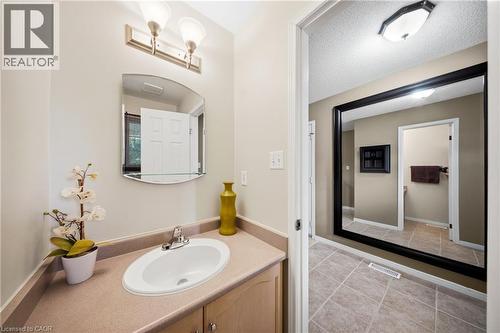 Bathroom vanity featuring a light-colored countertop, an oval undermount sink, and a brushed nickel faucet - 16 Scottacres Boulevard, Caledonia, ON - Indoor Photo Showing Bathroom