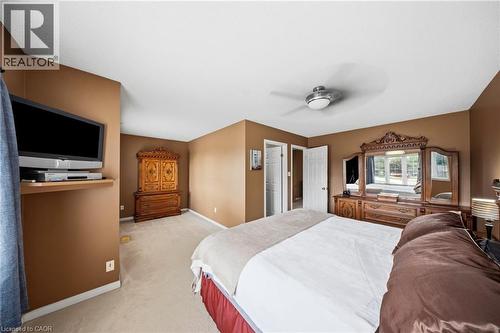 Carpeted bedroom featuring neutral-toned walls, white trim, and a ceiling fan with integrated lighting - 16 Scottacres Boulevard, Caledonia, ON - Indoor Photo Showing Bedroom