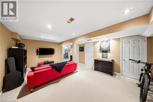 Spacious recreation room featuring recessed lighting, neutral carpeting, and a built-in media wall - 16 Scottacres Boulevard, Caledonia, ON - Indoor