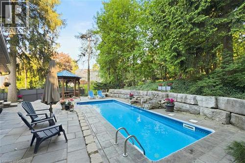 Pool and patio view with waterfall - 18 Stonegate Drive, Hamilton, ON 