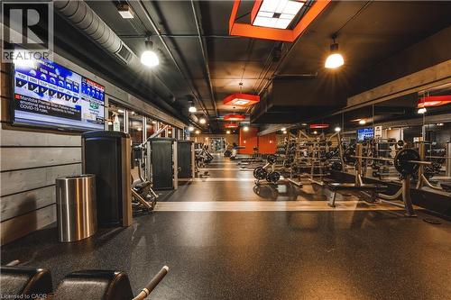 Spacious fitness center featuring varied exercise equipment, wall-mounted television, exposed ductwork, mirrored walls, and recessed lighting - 1235 Richmond Street Unit# 1406, London, ON 