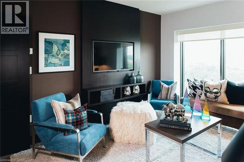 Living area featuring a dark accent wall with an integrated media console, a television, and floor-to-ceiling windows - 1235 Richmond Street Unit# 1406, London, ON 