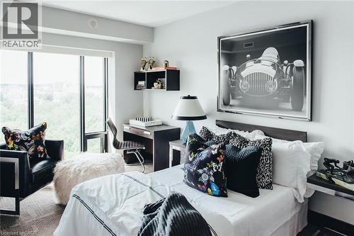 Bedroom featuring full-height window, wall-mounted shelving, built-in desk, and carpeting - 1235 Richmond Street Unit# 1406, London, ON 