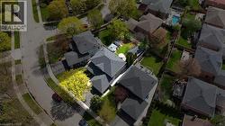 Aerial perspective showcasing a residential property with a dark shingle roof and a spacious backyard featuring a manicured lawn - 