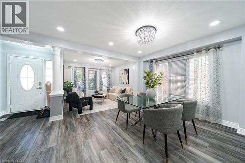 Spacious open-concept interior featuring wood-finish flooring, recessed lighting, and a crystal chandelier - 151 Baldwin Drive, Cambridge, ON 