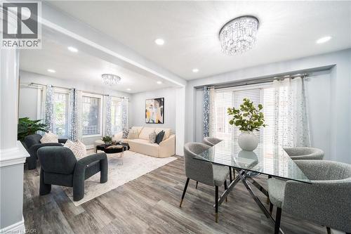 Open-concept living and dining areas featuring wood-finish flooring, recessed lighting, and a crystal chandelier - 151 Baldwin Drive, Cambridge, ON - Indoor