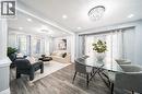 Open-concept living and dining areas featuring wood-finish flooring, recessed lighting, and a crystal chandelier - 151 Baldwin Drive, Cambridge, ON  - Indoor 