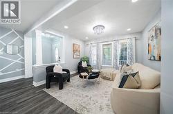 Living area featuring wood-finish flooring, recessed lighting, and a decorative chandelier - 